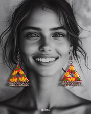 A model wearing the Zarmin floral triangle earrings, highlighting the bold hand-painted patterns in pink and yellow, and showcasing their playful silhouette with silver jhumki detailing that adds movement and charm, Muselot.