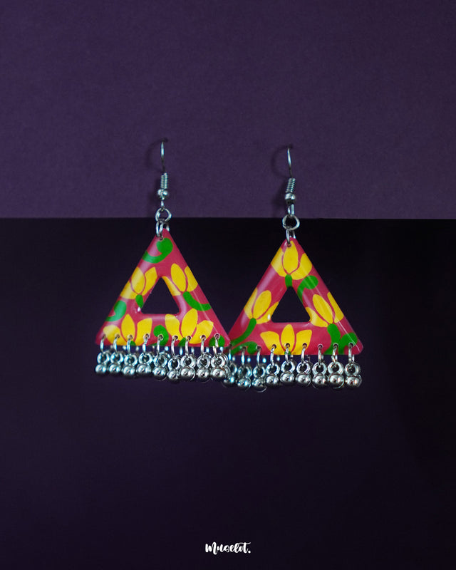 Zarmin floral triangle earrings feature bold pink and yellow hand-painted blooms set against a vibrant base, highlighted by a delicate row of silver-toned ghungroos that add a subtle jingle—showcasing their handmade charm and festive flair — Muselot.