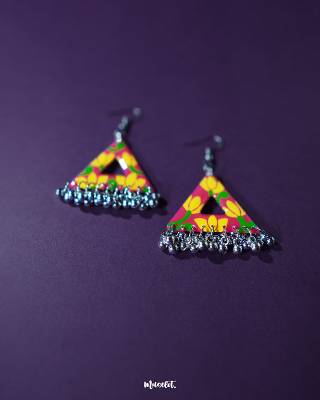 Zarmin triangle floral earrings with hand-painted yellow and pink blooms on a vivid red base, highlighting their unique triangular shape and showcasing the intricate silver jhumki drops that lend a traditional twist to a bold, artistic design — Muselot.
