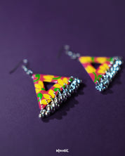 The Zarmin triangle floral earrings are a vibrant celebration of handcrafted artistry, highlighting bold yellow blooms on a red base and showcasing delicate silver jhumki drops that bring traditional charm to this modern geometric design — Muselot.