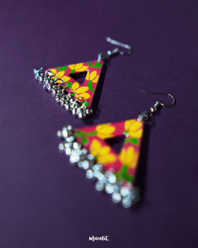 Zarmin triangle floral earrings captured in a zoomed-in angle to showcase the intricate floral carvings, oxidized silver finish, and dainty jhumki accents, emphasizing the handcrafted elegance — Muselot.
