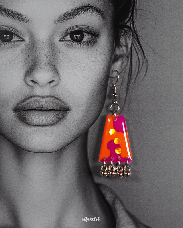 Model wearing the abstract Laalsavera earrings, with bold strokes of red and orange highlighted against her skin, enhancing the artistic appeal of the design while adding a touch of regal drama – Muselot