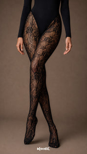 A close up view of crossed legs wearing full-length black stockings with intricate rose floral lace, fine fishnet mesh and covered toes-Muselot
