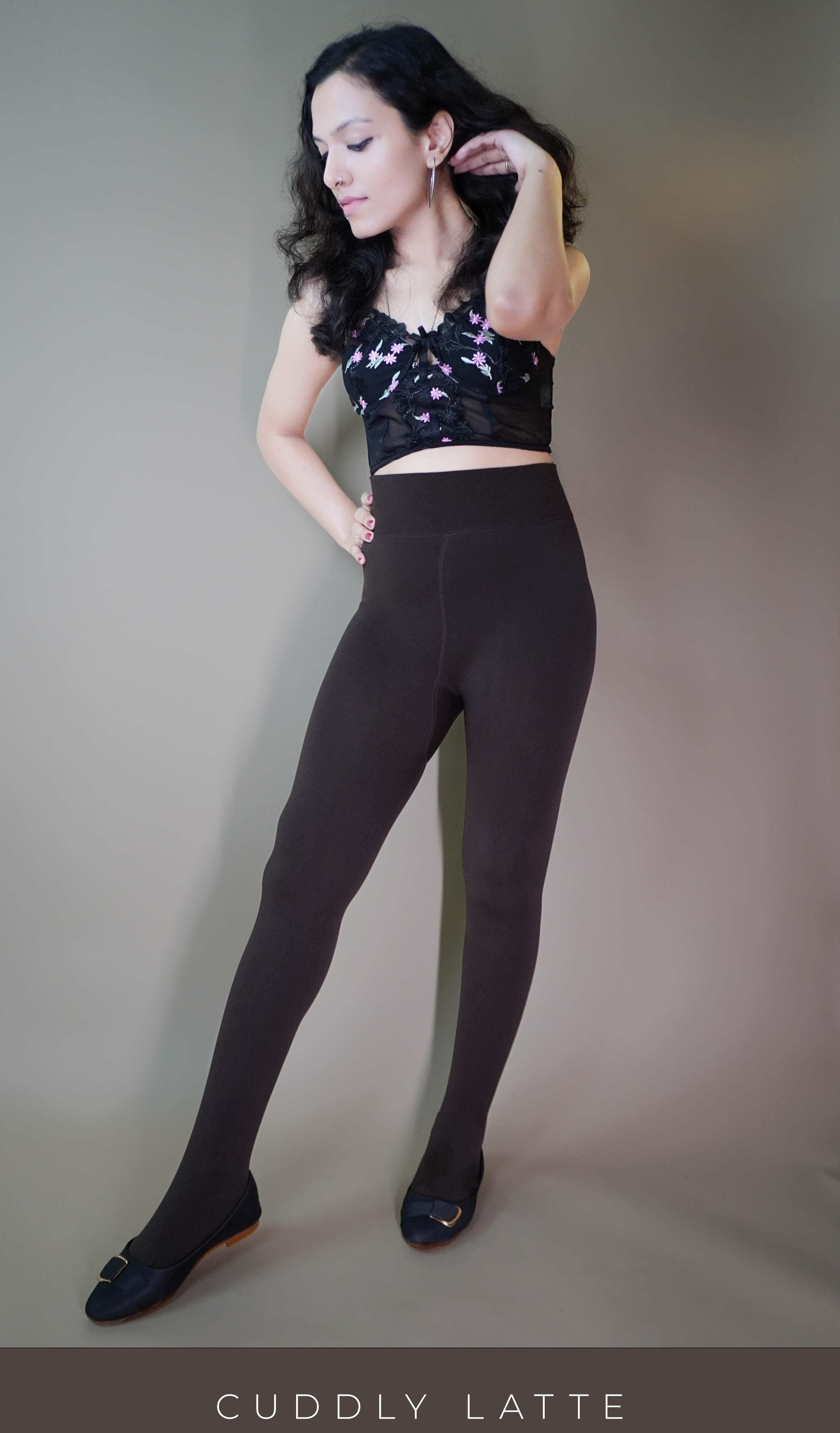 A model, wearing body-hugging brown warm tights, highlighting their snug fit that contours to the body while providing warmth and comfort. The rich brown hue adds depth to the outfit, making these tights both a stylish and cozy option for cooler weather. -Muselot