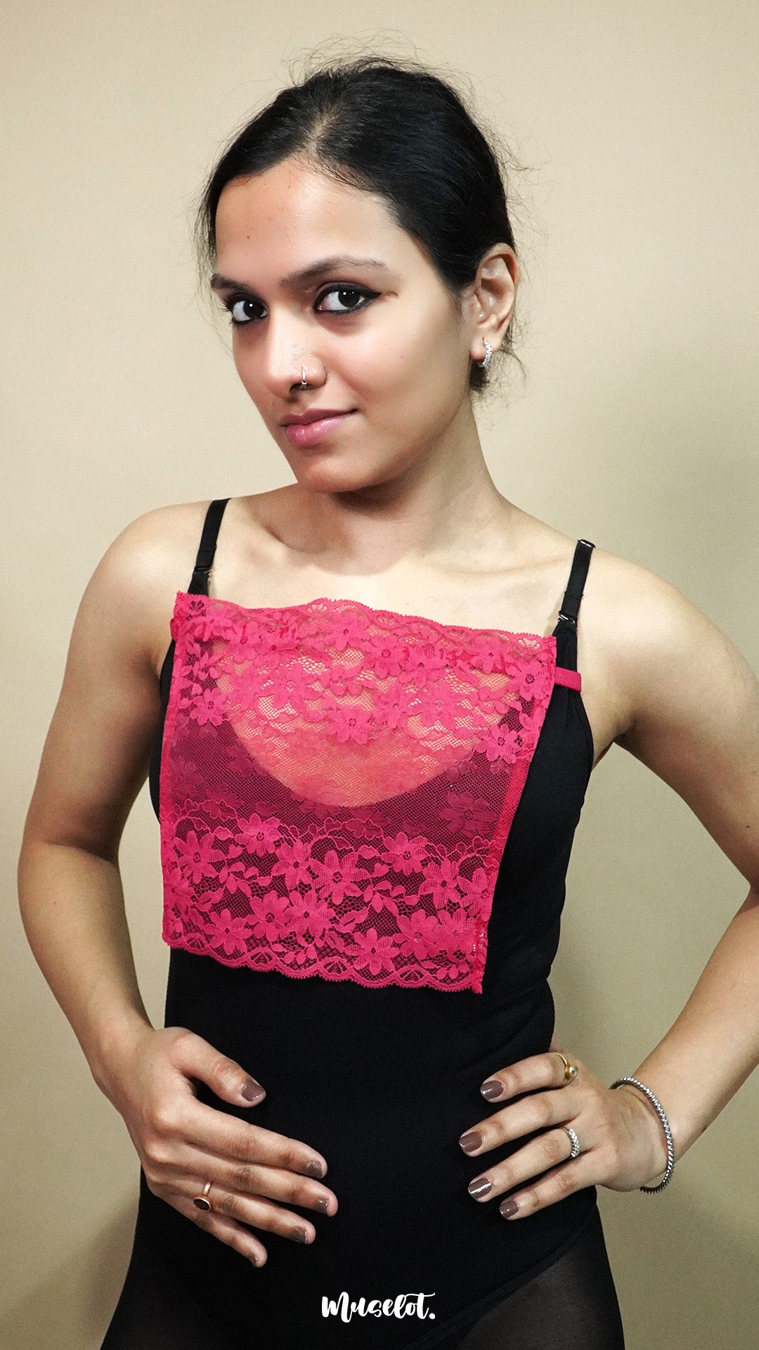 front view of woman holding dark pink lace camisole insert to show width and coverage on beige background, highlighting deep neck cover styling with lace mock camisole – muselot