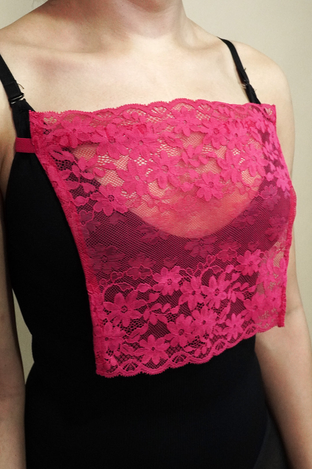 side angle close up of woman wearing dark pink lace camisole insert over black top on beige background, highlighting floral lace design and wide coverage for low neckline outfits – muselot