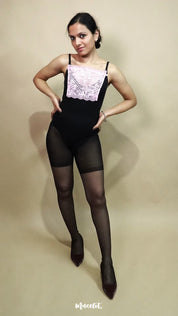 full body view of woman wearing baby pink lace camisole insert over black dress on beige background, showcasing neat neckline coverage with wide lace mock camisole for deep neck outfits – muselot
