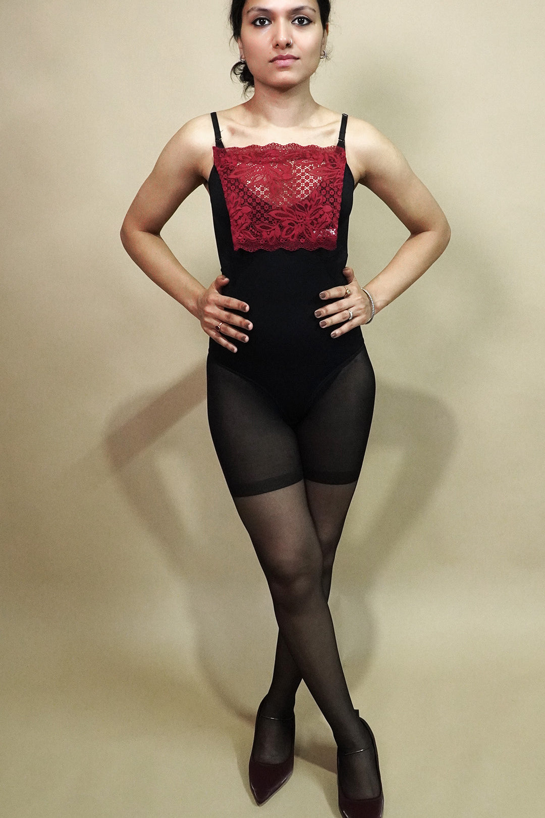 full body view of woman wearing maroon lace camisole insert over black outfit on beige background, highlighting deep neck coverage styling with lace mock camisole for modest layering – muselot