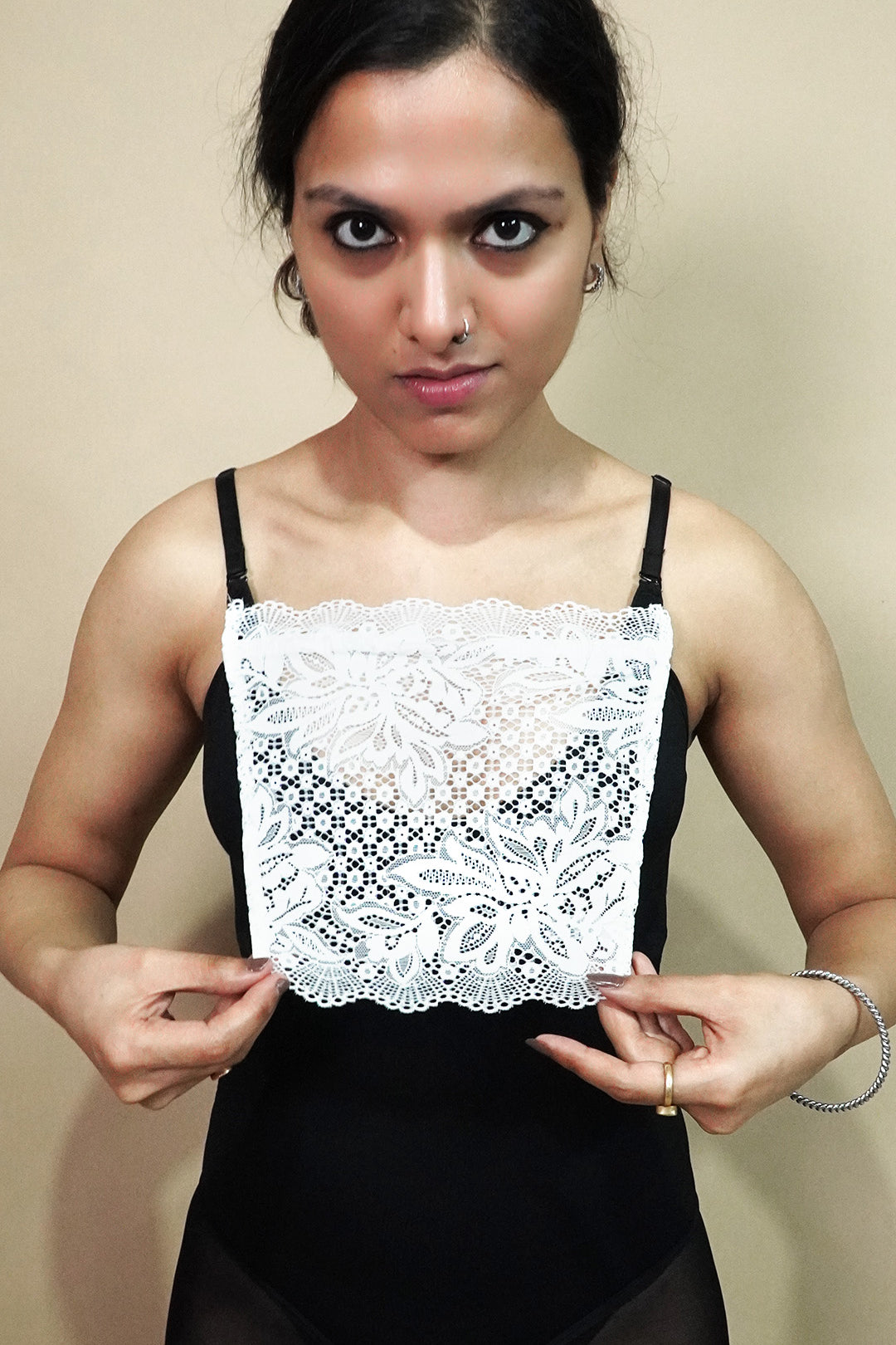 front view of woman holding white lace camisole insert to display full width and shape, showing mock lace layer used for covering deep neck tops neatly – muselot