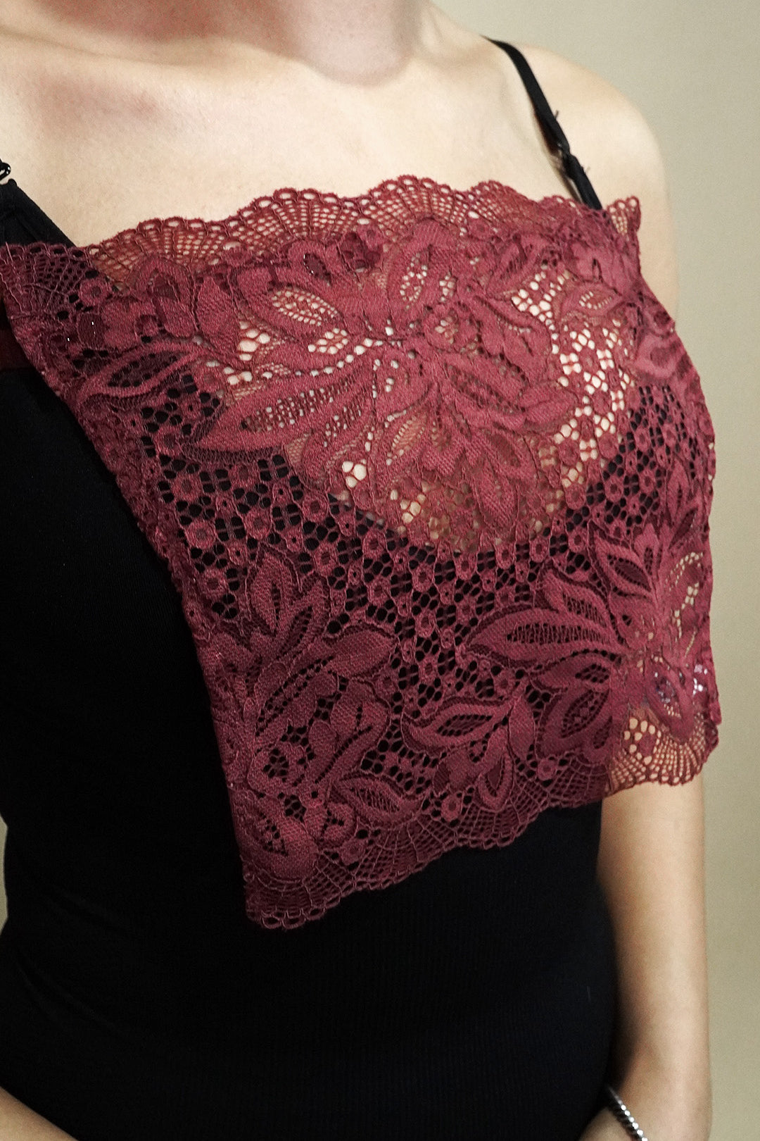 close up of woman wearing muselot burgundy lace camisole insert over black top on beige background, highlighting floral lace neckline coverage for deep neck dresses and cleavage cover styling-Muselot