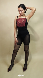 Full body view of woman wearing burgundy lace camisole insert over black outfit on plain beige background, showcasing deep neck coverage styling with lace camisole for modest layering under low neckline dresses – muselot