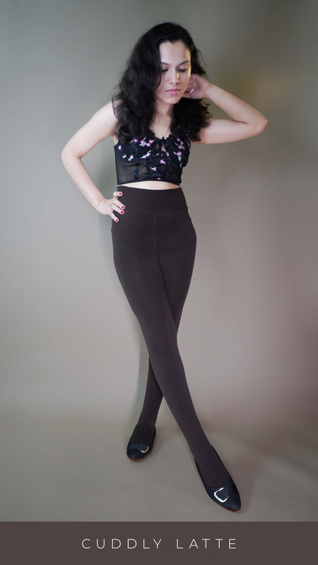 A model, wearing closed-feet dark brown warm stockings, is showcasing their thick, insulating fabric that offers both warmth and comfort. The deep dark brown color highlights a sleek, full-coverage design, making them a stylish and cozy choice for colder days. -Muselot