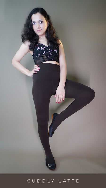 A model, wearing dark brown warm tights, is showcasing their smooth, thick fabric that offers a snug fit and ample warmth. The deep brown hue highlights a classic, versatile look, making these tights a stylish and practical addition to any cold-weather outfit. -Muselot