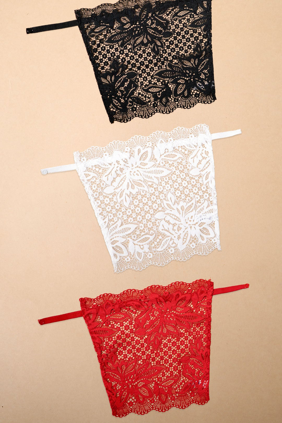 A pack of 3 deep neck cover-up clip-on camisoles displayed on a beige background, featuring black, white and red lace neckline inserts with premium floral lace detailing, adjustable straps and elegant modesty coverage for deep neck tops, blouses, kurtis and dresses-Muselot