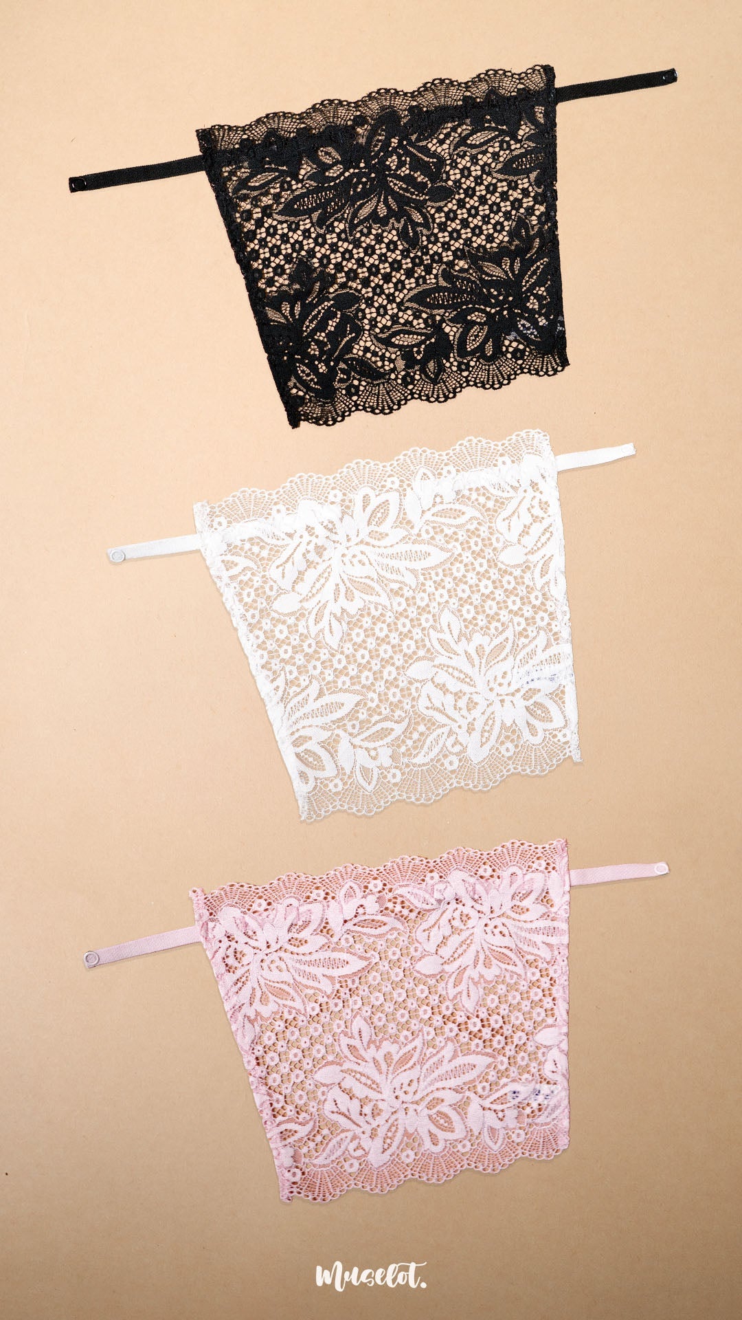 A pack of three clip-on neckline covers in black, white and baby pink is displayed on a beige background. Crafted with premium floral lace and adjustable straps, these deep neck cover-ups add elegant neckline coverage to dresses, tops, kurtis and blouses. The lightweight lace design blends seamlessly with different necklines, offering a stylish modesty panel, layering accessory and feminine fashion accent without the need for a full camisole – Muselot
