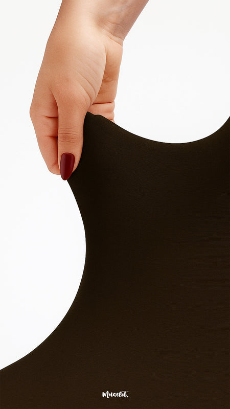 A detailed close-up of a hand stretching durable brown opaque tights, highlighting strong elasticity, tear resistance, and smooth finish - Muselot
