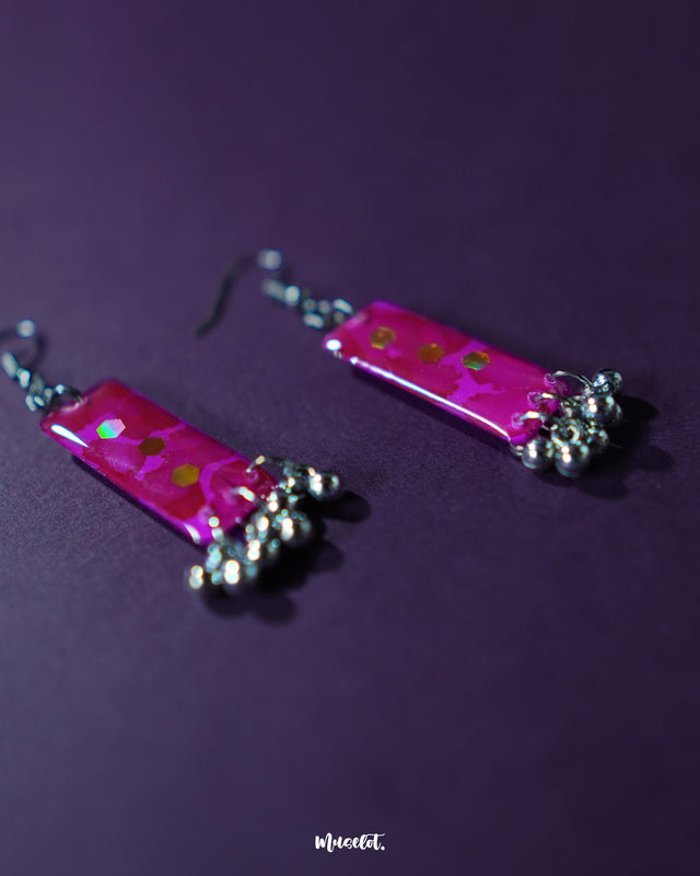 Floral drop earrings resting on a plain background, highlighting their delicate petal design and elegant charm – Muselot