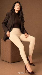 A seated view of skin tone fur lined tights with a high waistband, smooth opaque fabric and open-foot ankle cuffs - Muselot