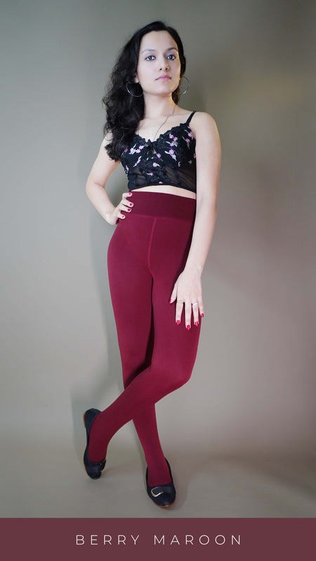 A model, wearing fur-lined berry maroon warm stockings, is highlighting their plush, insulating texture that offers both warmth and a luxurious feel. The rich berry maroon color complements the cozy design, making these stockings a stylish and comfortable choice for colder days. -Muselot