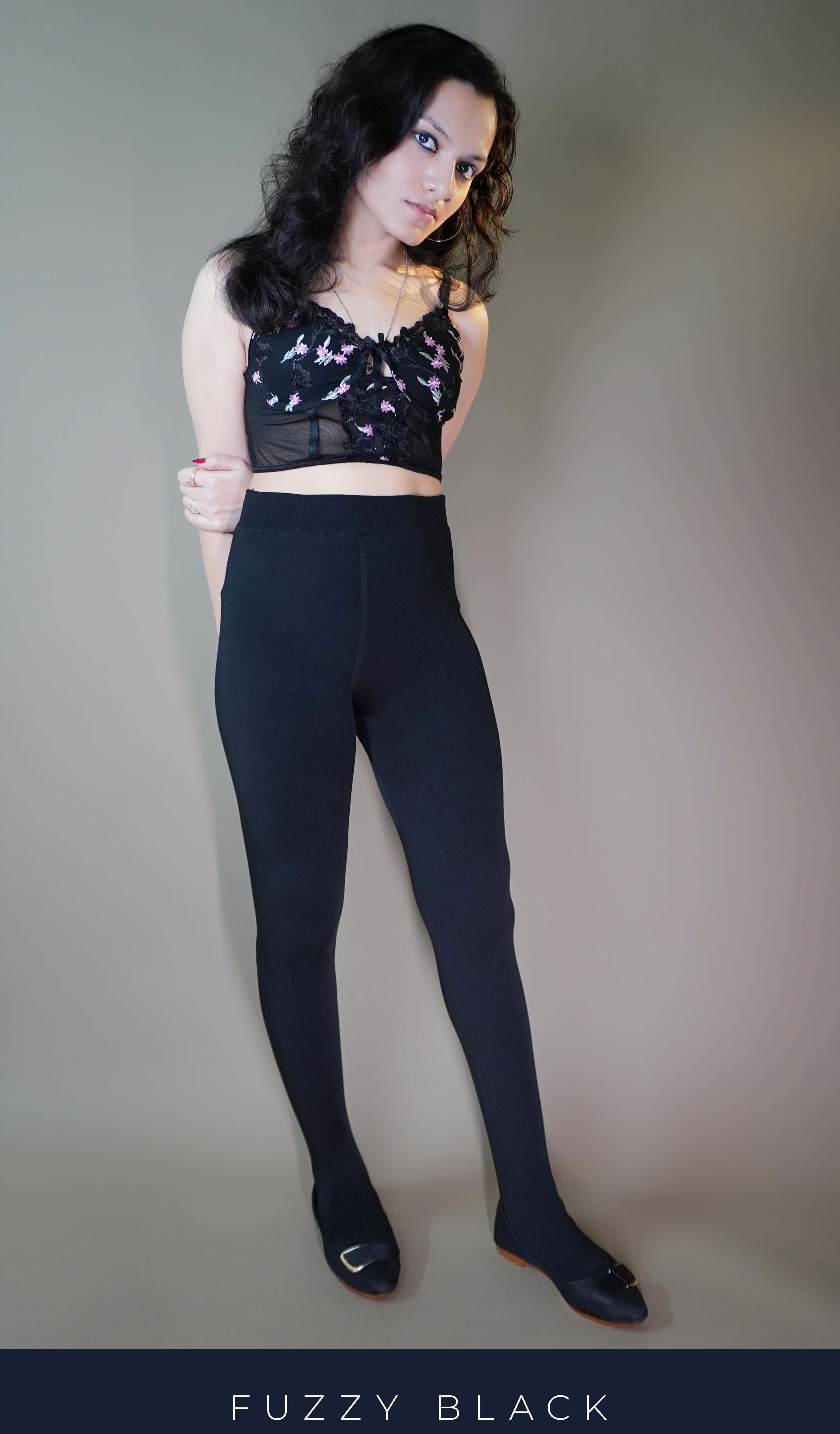 A confident model, wearing fur-lined warm black tights, highlighting their thick, cozy fabric that offers both insulation and comfort. The tights embrace the legs with a smooth, snug fit, making them the perfect blend of warmth and style for colder weather. -Muselot