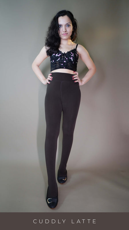 A model, wearing fur-lined cuddly latte warm tights, showcasing their soft, plush texture for added warmth. The latte color provides a cozy, stylish look perfect for colder weather. -Muselot
