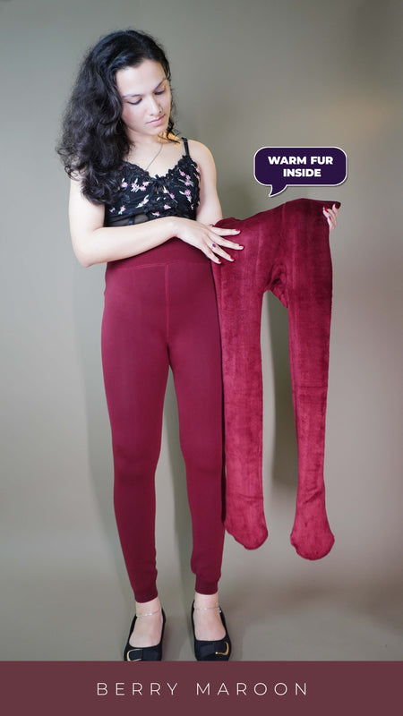 A model, wearing furry berry maroon stockings, and also holding  the tights inside out, showcasing  its plush fur texture. The rich berry color enhances the cozy, luxurious feel, highlighting the softness and warmth of the tights. -Muselot
