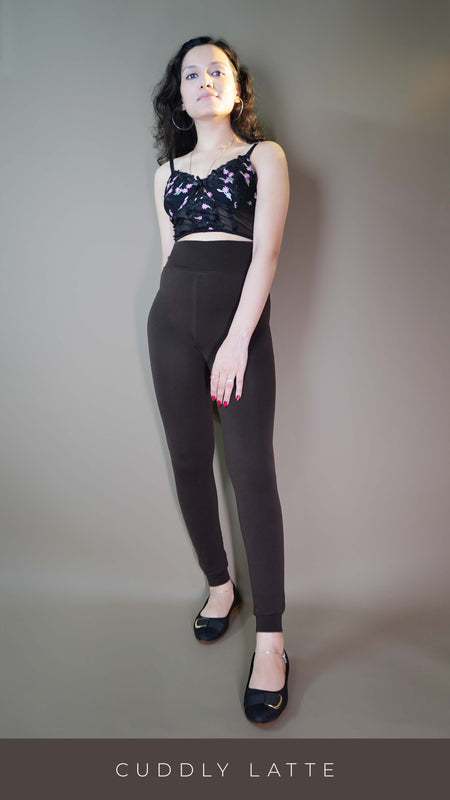 A model, wearing furry bliss cuddly latte warm tights, showcasing their soft, velvety texture that offers both warmth and comfort. The warm latte color adds a cozy, neutral tone, while the fluffy design highlights a snug fit perfect for chilly days. -Muselot