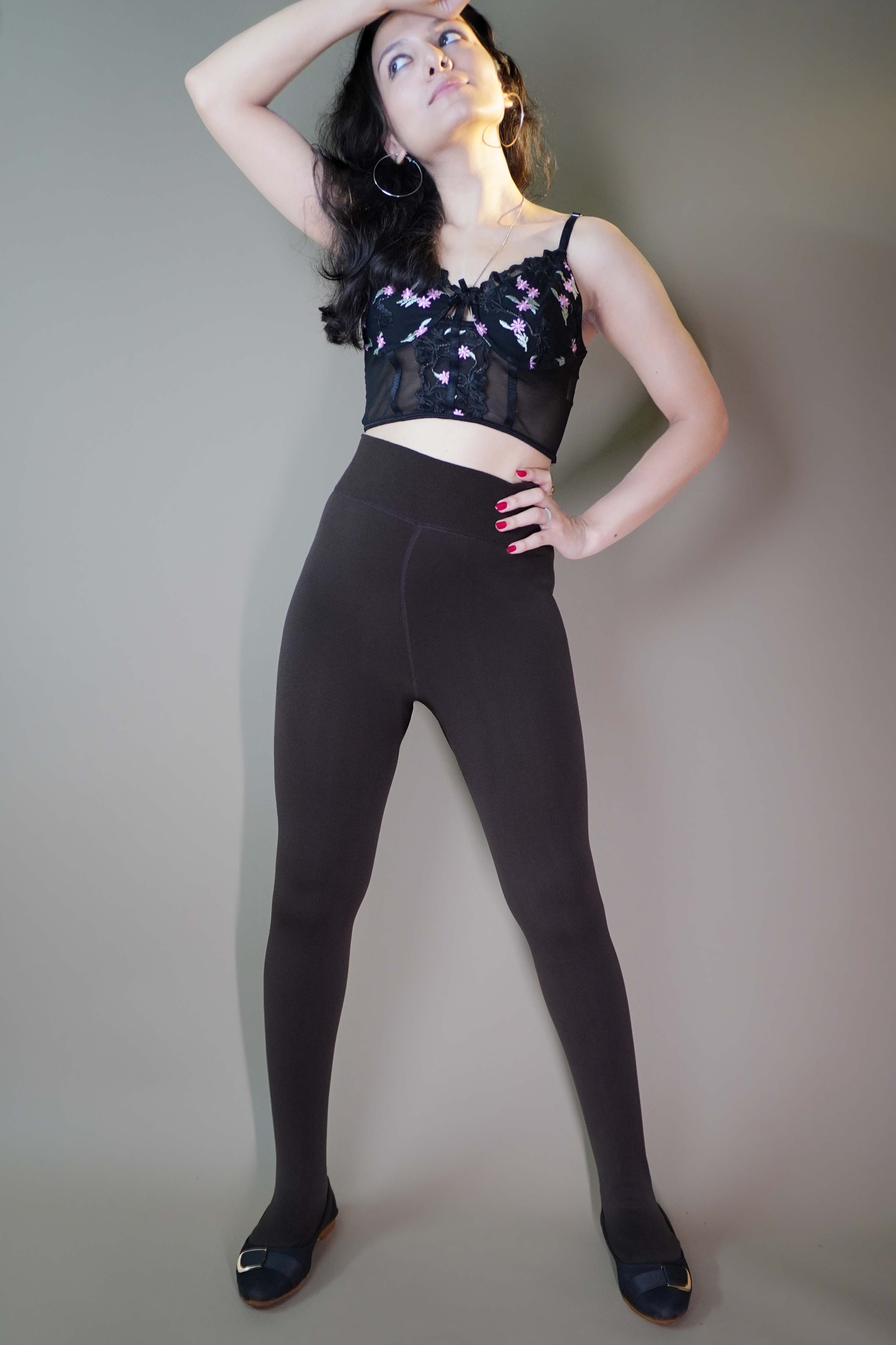 A model, wearing furry cuddly latte stockings, posing confidently highlighting their soft, plush texture for ultimate warmth and comfort. The latte color adds a cozy, stylish touch, making them perfect for chilly days. -Muselot