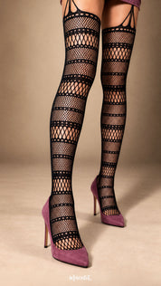 A close-up shot of a woman wearing black striped fishnet garter stockings with mauve pointed heels, highlighting the alternating fine mesh, open diamond-knit bands and decorative strappy detailing at the thighs - Muselot