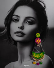 A woman wearing handcrafted chandbali earrings with vibrant motifs and playful accents, highlighting cultural flair and showcasing a joyful blend of tradition and creativity — Muselot.