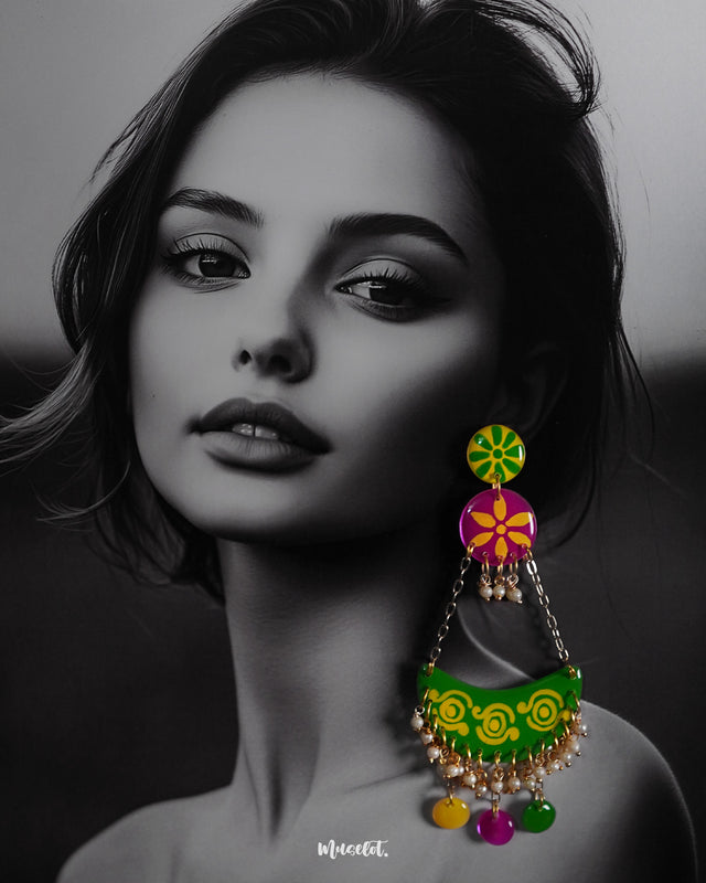 A woman wearing handcrafted chandbali earrings with vibrant motifs and playful accents, highlighting cultural flair and showcasing a joyful blend of tradition and creativity — Muselot.
