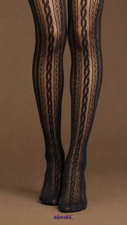 Close-up of black designer lace stockings showing the intricate vertical braid pattern, fine fishnet texture and closed-foot construction on the lower legs and feet.