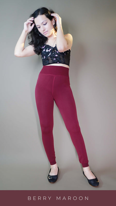 A model, wearing stylish maroon warm tights, is showcasing their rich color and sleek design. The tights highlight a perfect blend of fashion and warmth, offering both comfort and a chic touch to any outfit. -Muselot
