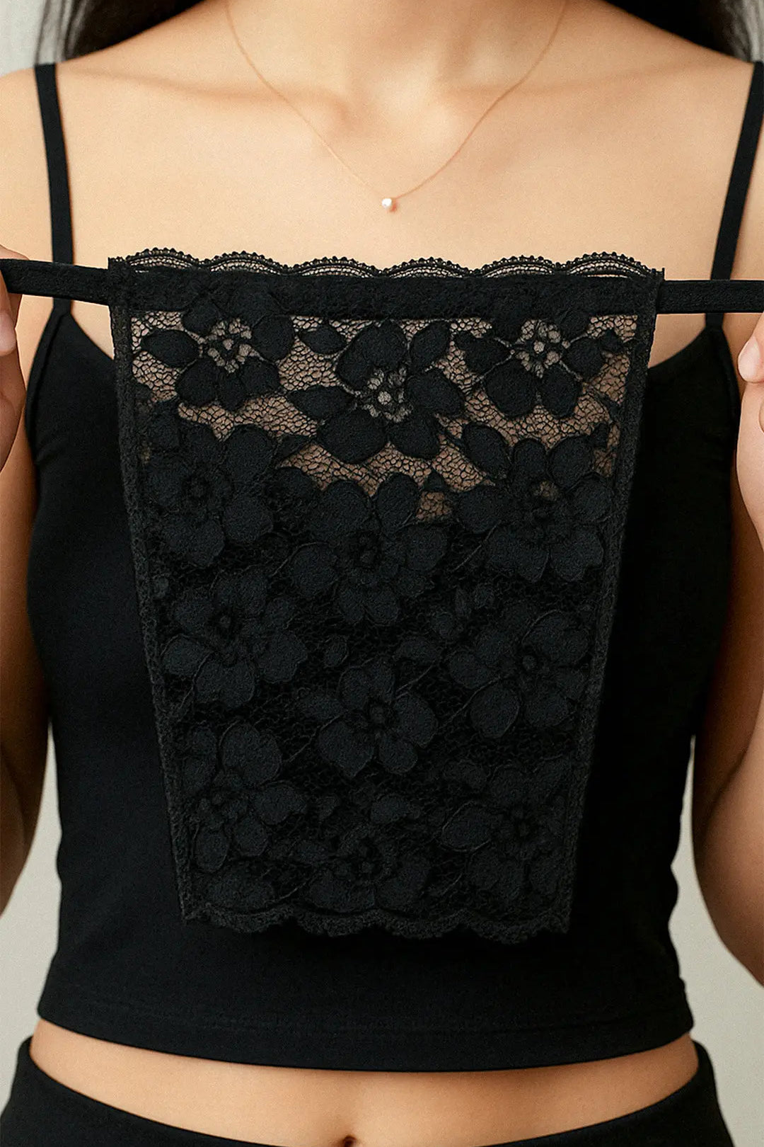 Close-up of model holding Lacy Black Mockers, showcasing the intricate lace pattern and refined design for effortlessly styling deep-neck outfits – Muselot.