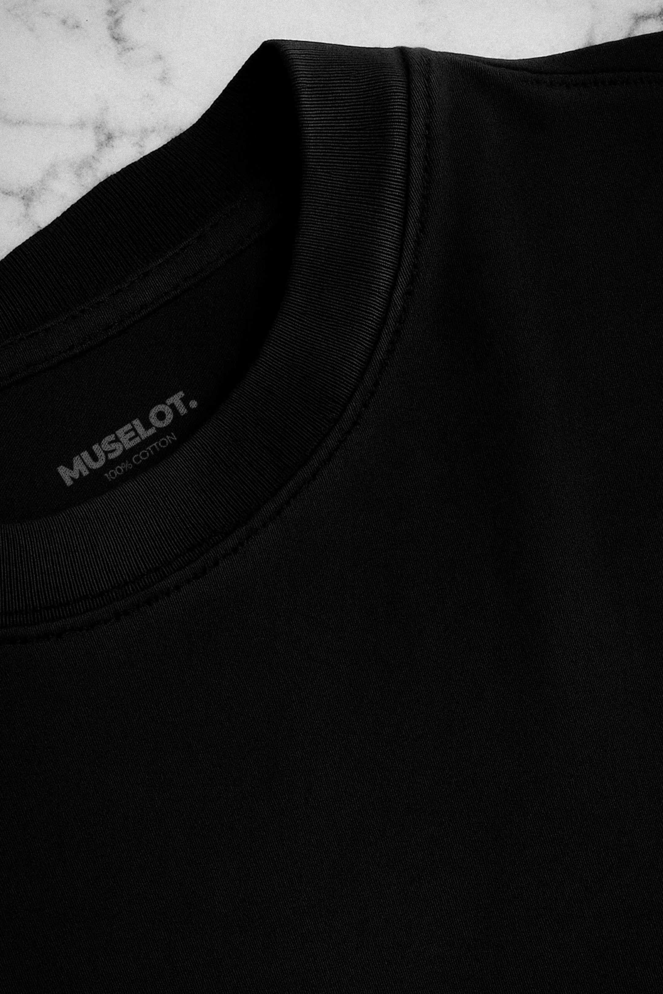 Close-up shot of the neckline of a unisex oversized black t-shirt, showcasing the detailed stitching and subtle logo, emphasizing its premium design and quality craftsmanship-Muselot