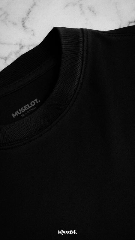 Close-up shot of the neckline of a unisex oversized black t-shirt, showcasing the detailed stitching and subtle logo, emphasizing its premium design and quality craftsmanship-Muselot