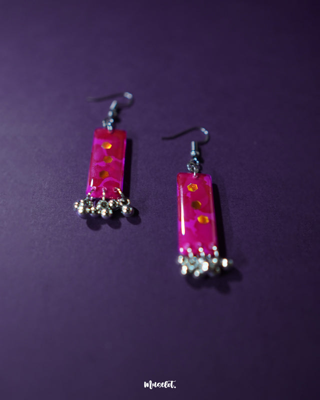 Close-up shot of red drop earrings adding a bold and elegant touch, showcasing their vibrant hue and sleek design – Muselot