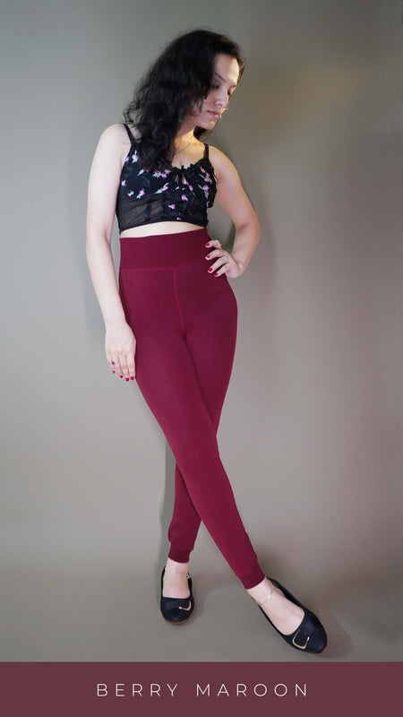 A model, wearing warm maroon tights for women, is highlighting their snug, soft material that keeps the legs warm in colder weather. The vibrant maroon shade adds a sophisticated pop of color, while the design ensures both comfort and style. -Muselot